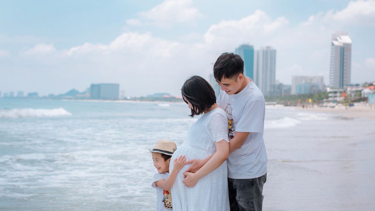 Família aproveitando a praia em uma área de sombra na areia