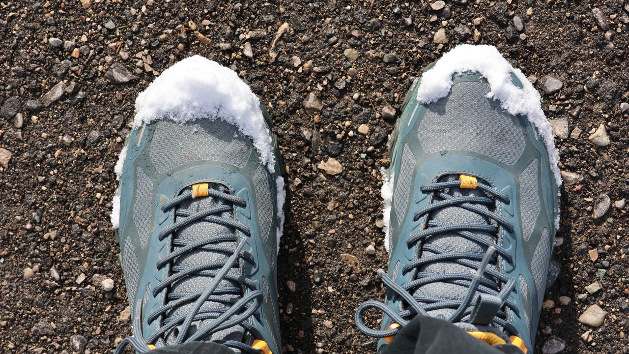 Botas de trekking sobre a neve em uma trilha de inverno