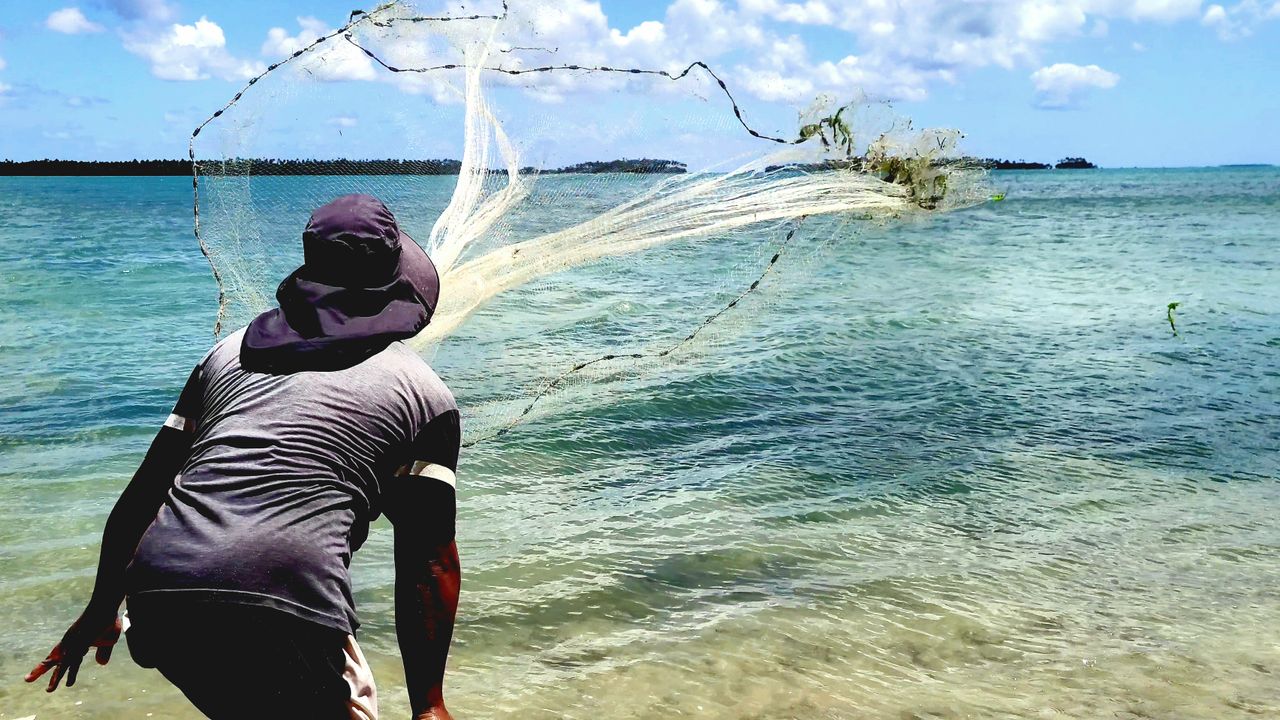 Pescador sob o sol forte usando roupa de proteção