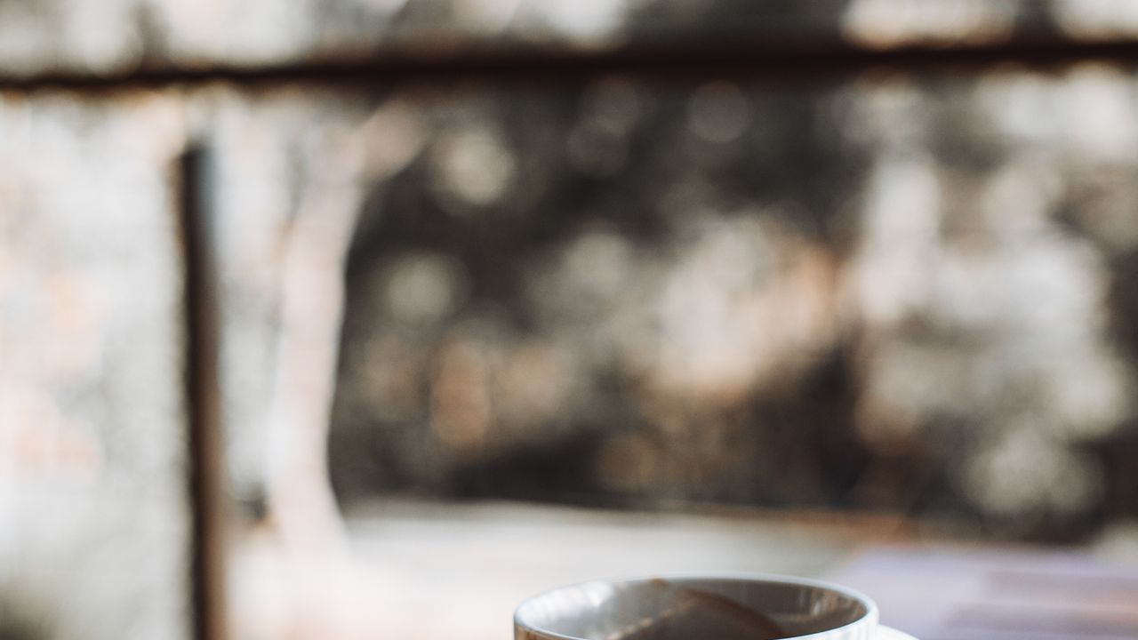 Café servido em caneca ao ar livre em uma mesa de madeira