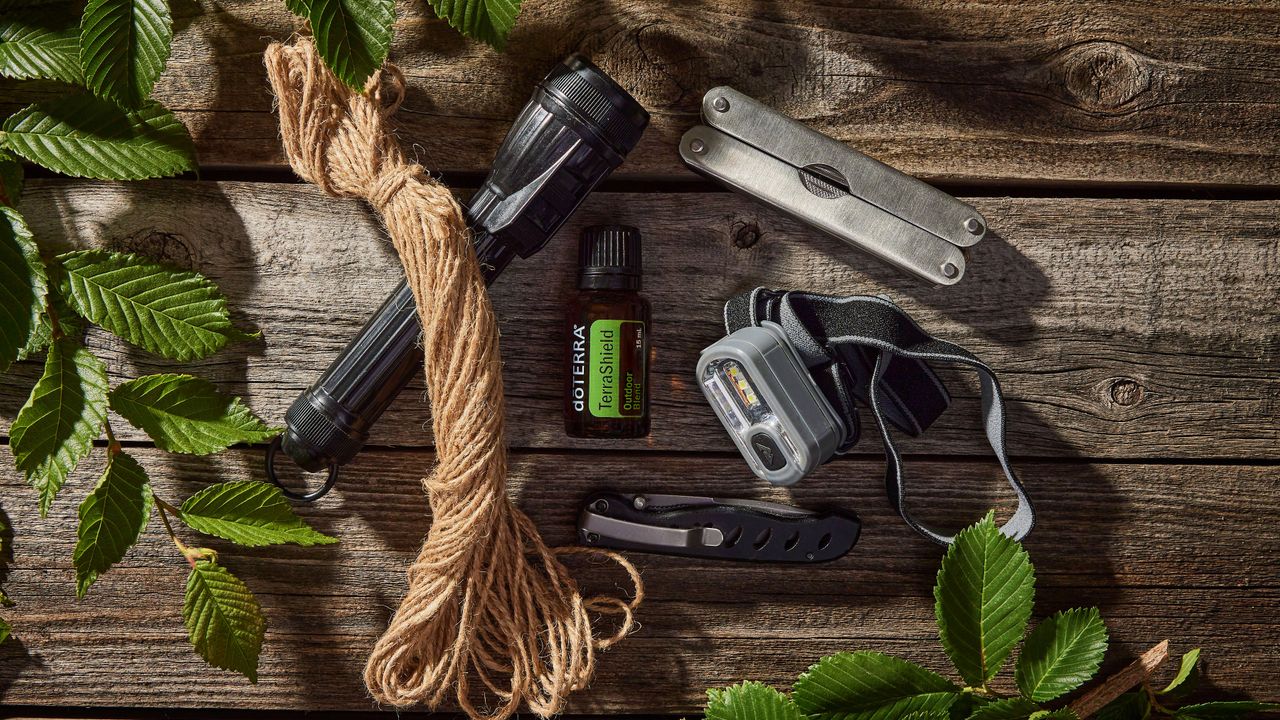 Canivetes e ferramentas de camping dispostos sobre uma mesa de madeira