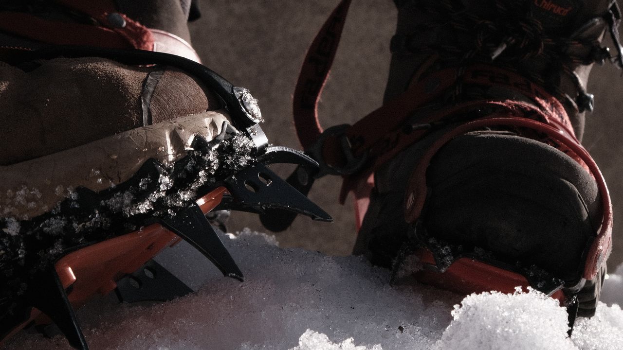 Botas de montanhismo com crampons em terreno de neve