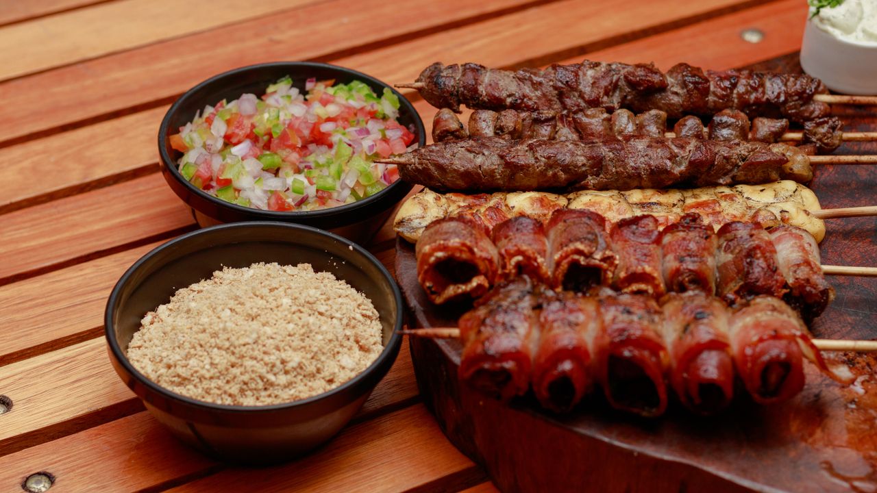 Espetos de carne grelhando na churrasqueira