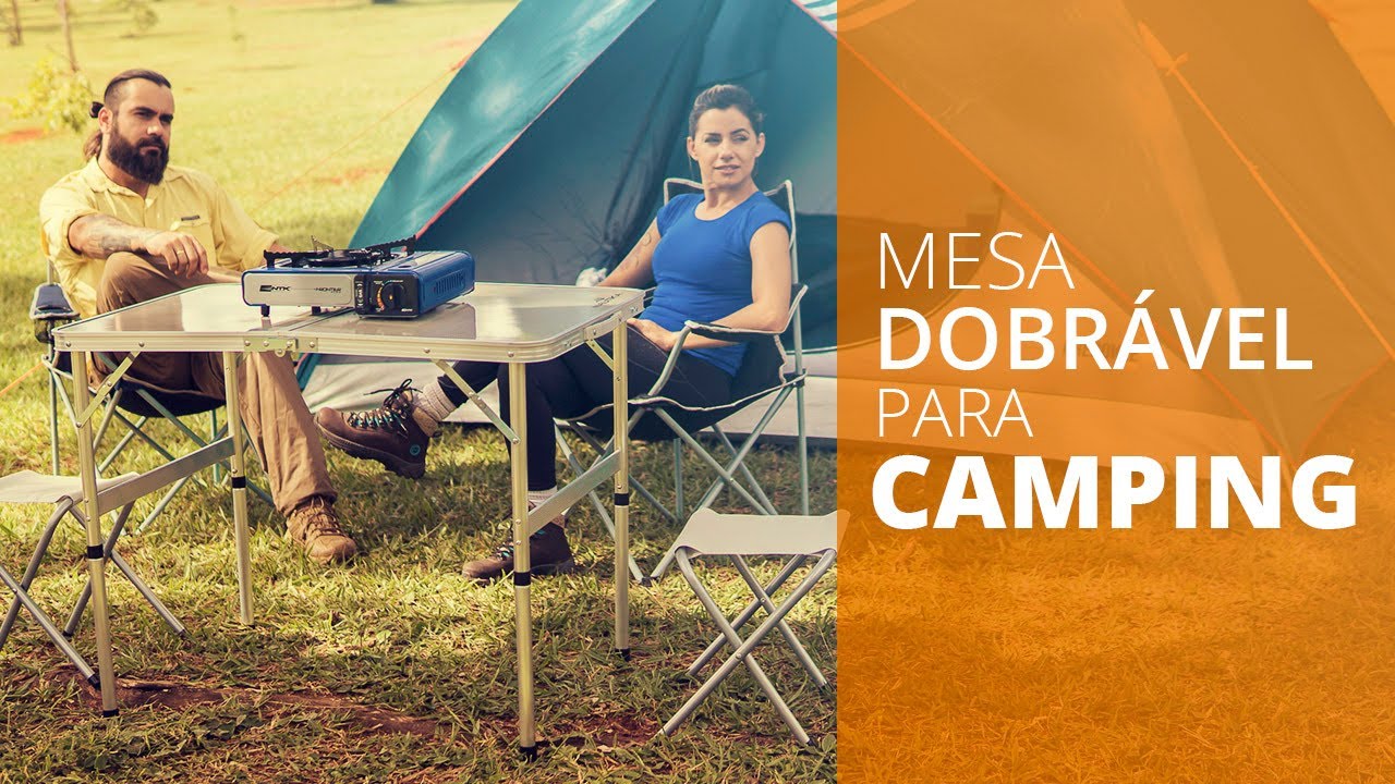 Mesa de camping dobrável tipo maleta sendo montada ao ar livre